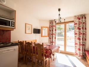 a kitchen with a dining room table with chairs and a window at Appartement Lanslevillard, 3 pièces, 5 personnes - FR-1-508-139 in Lanslevillard