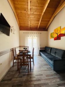 a living room with a couch and a table with chairs at Jimmy's Apartment Lefkada, Katochori in Katokhórion
