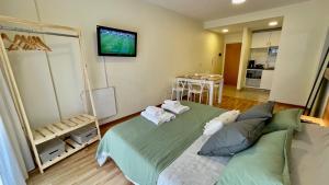 um quarto com uma cama e uma televisão na parede em Green Palermo em Buenos Aires