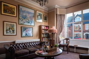 a living room with a leather couch and a table at The House on Cabbell in Cromer