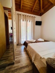 een slaapkamer met 2 bedden en een groot raam bij Jimmy's Apartment Lefkada, Katochori in Katochorion