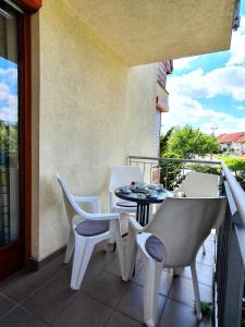 eine Terrasse mit einem Tisch und Stühlen auf dem Balkon in der Unterkunft Trend Baláca Home in Veszprém