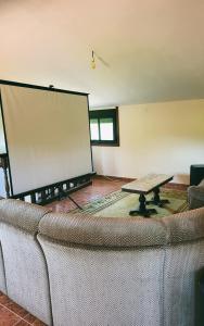 a large screen in a room with a couch and a table at Alojamiento Pena da Osa in Sober +29 photos