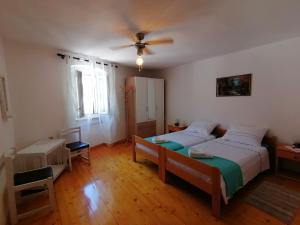 a bedroom with two beds and a ceiling fan at Bernik rooms in Plomin