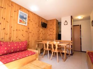 a room with a table and a couch and a dining room at Appartement chaleureux à 300m des pistes, 5 personnes, balcon, draps, parking - FR-1-508-228 in Lanslebourg-Mont-Cenis
