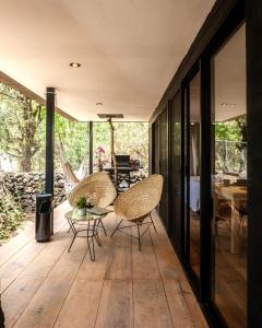 eine offene Terrasse mit Stühlen und einem Tisch in der Unterkunft Fungi Tepoz Cabins in Tlacotenco