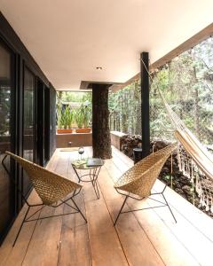 a house with a hammock on a deck at Fungi Tepoz Cabins in Tlacotenco