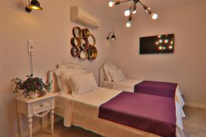 a bedroom with two beds and a table and a tv at Alacaat Otel in Alaçatı
