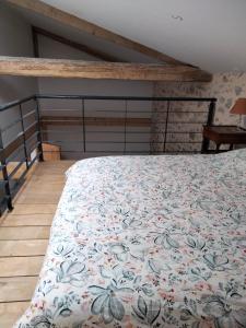 a bedroom with a bed with a floral bedspread at La Grange de Sabatas in Chomérac