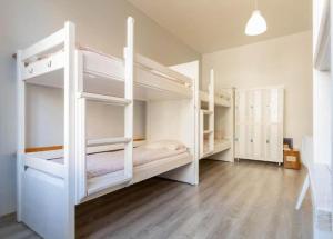 a room with two white bunk beds in it at Vibe Hostel Sopot in Sopot