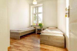 two beds in a room with a window at Vibe Hostel Sopot in Sopot