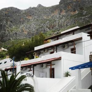 a white building with a mountain in the background at Blue Sand in Kalymnos