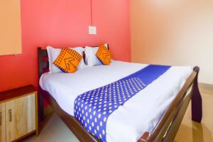 Panhāla的住宿－SPOT ON Hotel Diamond Lodging And Boarding，一张带橙色和蓝色枕头的床