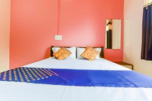 Panhāla的住宿－SPOT ON Hotel Diamond Lodging And Boarding，一间卧室设有蓝色和橙色的墙壁。