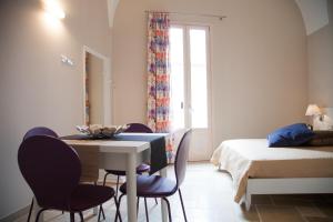 グラヴィーナ・イン・プーリアにあるLe Stanze di Finyaのテーブル、椅子、ベッドが備わる客室です。