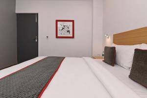 CharbaghSuper Townhouse Function Inn Near Chaudhary Charan Singh International Airport的一张大床,位于酒店客房内,