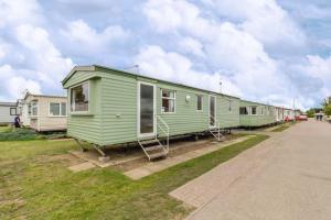 a row of mobile homes parked on the grass at 8 Berth Caravan At California Cliffs Holiday Park In Norfolk Ref 50007d in Great Yarmouth