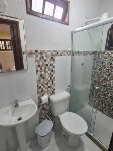 y baño con aseo, lavabo y ducha. en Suítes Casa do Barão, en Búzios