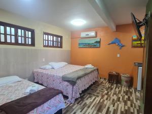 1 dormitorio con 2 camas y un pájaro en la pared en Suítes Casa do Barão, en Búzios