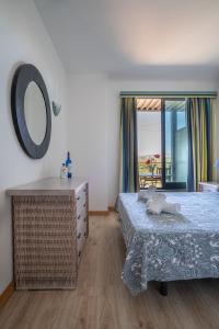 a bedroom with a bed and a mirror and a window at 1 Bed With Balcony Pool and Tennis in Quarteira