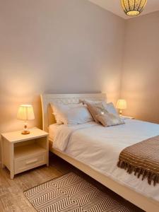 a bedroom with a bed and a nightstand with two lamps at Home Sweet Home in Quatre Bornes