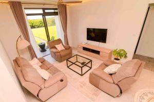 uma sala de estar com 2 sofás e uma televisão de ecrã plano em Home Sweet Home em Quatre Bornes