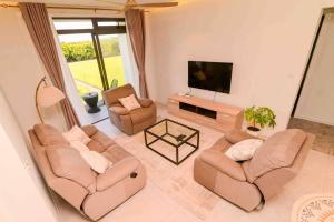 a living room with two couches and a flat screen tv at Home Sweet Home in Quatre Bornes