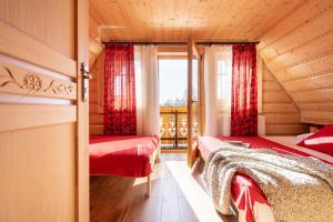 - une chambre avec 2 lits dans une cabane en rondins dans l'établissement Chocholowskie Domki, à Chochołów