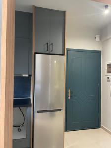 a kitchen with a refrigerator and a blue door at Lydia's Rainbow in Preveza +11 photos