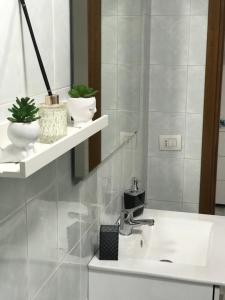 uma casa de banho com um lavatório e um espelho em Blue Wave Apartment em Bari