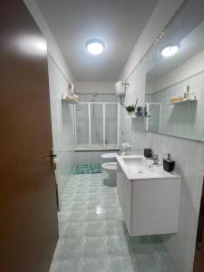 uma casa de banho branca com um lavatório e um WC em Blue Wave Apartment em Bari