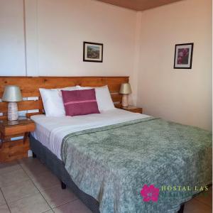 a bedroom with a large bed and two lamps at Hostal Puertas De Apaneca in Apaneca