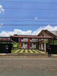 two people standing in front of a house at Hostal Puertas De Apaneca in Apaneca