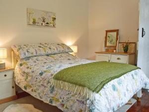 a bedroom with a bed and two night stands at Fern Cottage in Bardon Mill