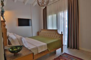 a bedroom with a bed and a large window at Alacaat Otel in Alaçatı