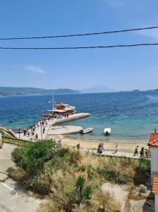 a beach with a group of people on the water at Gianni's Apartment By The Sea in Ammouliani