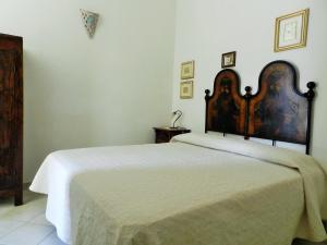 a bedroom with a large bed with a wooden headboard at Chicchiritanos in Monti