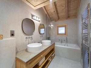 ein Badezimmer mit zwei Waschbecken und einer Badewanne und Spiegel in der Unterkunft Appartement neuf et cosy, proche des pistes, avec cheminée et parkings dédiés - FR-1-570-11 in Levassaix