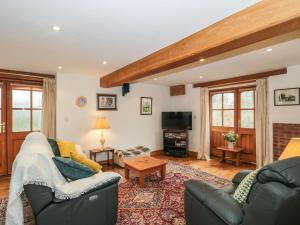 ein Wohnzimmer mit 2 Sofas und einem TV in der Unterkunft Oak Barn in Cullompton