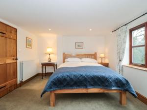Schlafzimmer mit einem Bett und einem Fenster in der Unterkunft Oak Barn in Cullompton