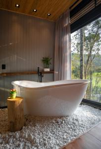 a white bath tub in a bathroom with a window at Green Barn Hotel & Bistro in Urubici