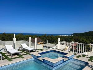 a swimming pool on a patio with two chairs at Luxury 1 Bedroom & Rooftop Pool unit #2 in Falmouth