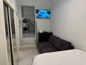a living room with a couch and a television at Luxury 1 Bedroom & Rooftop Pool unit #2 in Falmouth