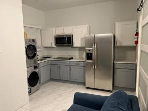 eine Küche mit einem Kühlschrank und Geräten aus Edelstahl in der Unterkunft Luxury 1 Bedroom & Rooftop Pool unit #2 in Falmouth