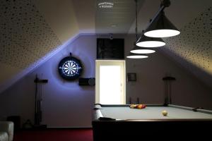 a room with a pool table and a clock on the wall at Apartmány u Romany in Mírkovice
