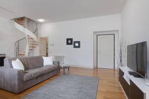 ein Wohnzimmer mit einem Sofa und einem TV in der Unterkunft Apartments Trieste Centro I 3 in Triest