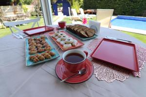 a table with plates of pastries and a cup of coffee at Alacaat Otel in Alaçatı