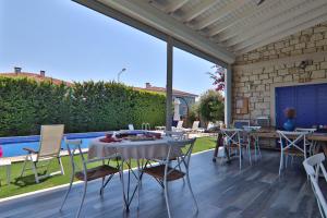 a patio with a table and chairs and a pool at Alacaat Otel in Alaçatı