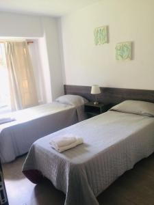 a hotel room with two beds and a window at Hermosa casa con Jacuzzi y sauna en Chacras de Coria in Ciudad Lujan de Cuyo