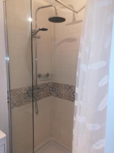 y baño con ducha y puerta de cristal. en Le Gîte insolite Gonnedouillé en Gonneville-en-Auge